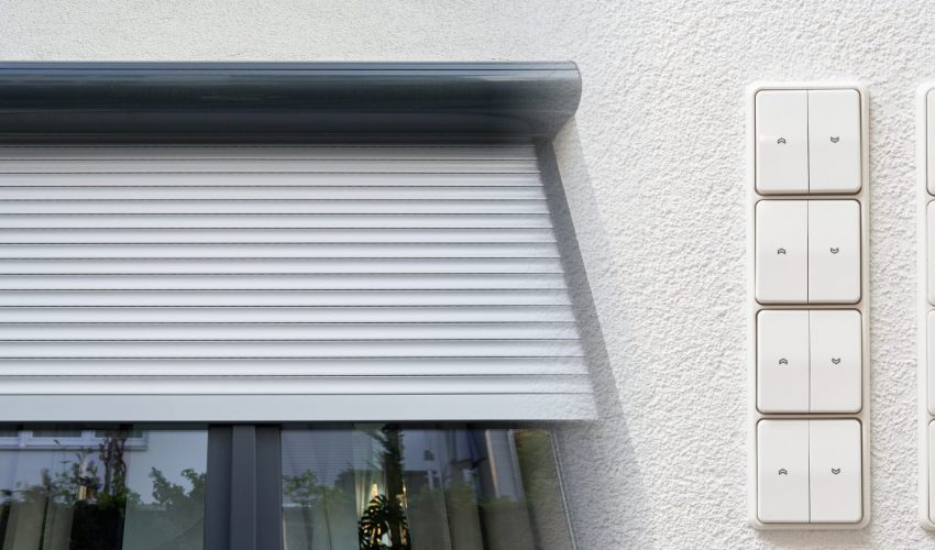 Modern electric roller shutter on window and control switches.